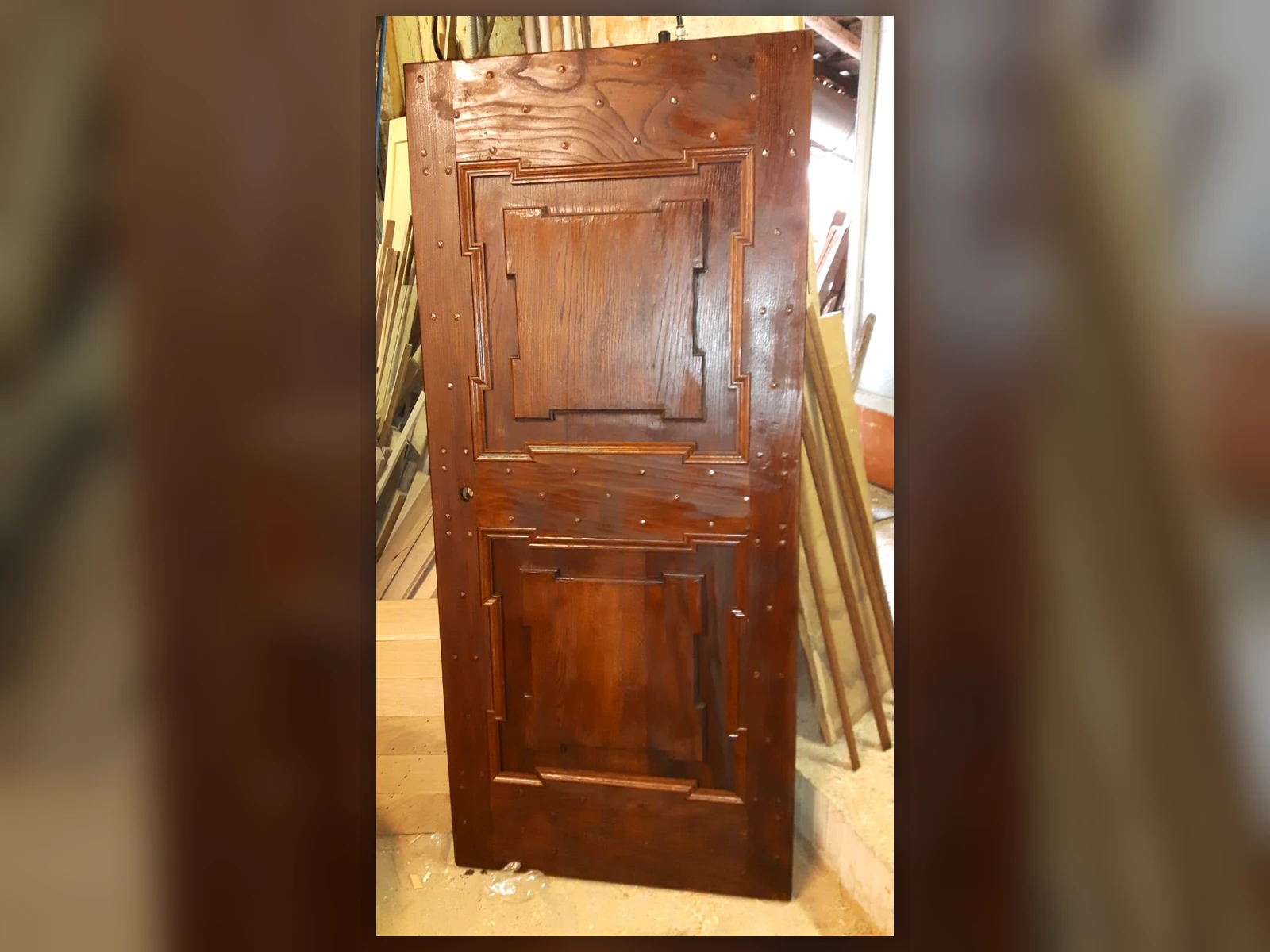 Porta antica in legno durante la fase di finitura del restauro