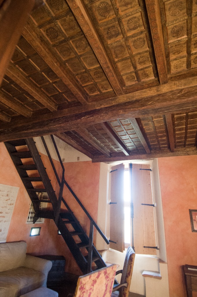 Soffitto ligneo a cassettoni ricostruito a mano, con travi e riquadri decorati